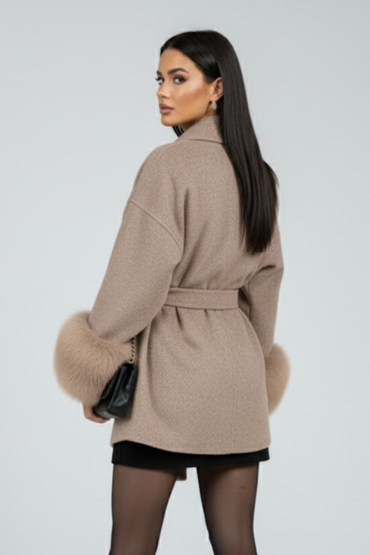 Fashionable women's full-length coat. Belted, elegant outerwear with cozy faux fur cuffs. Ideal for winter.