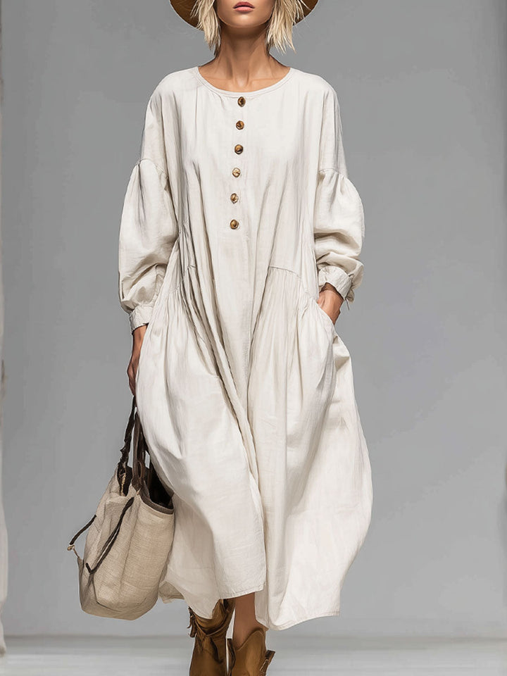 Beige women's loose-fit midi dress with button-front, long sleeves, and pockets for casual everyday wear.