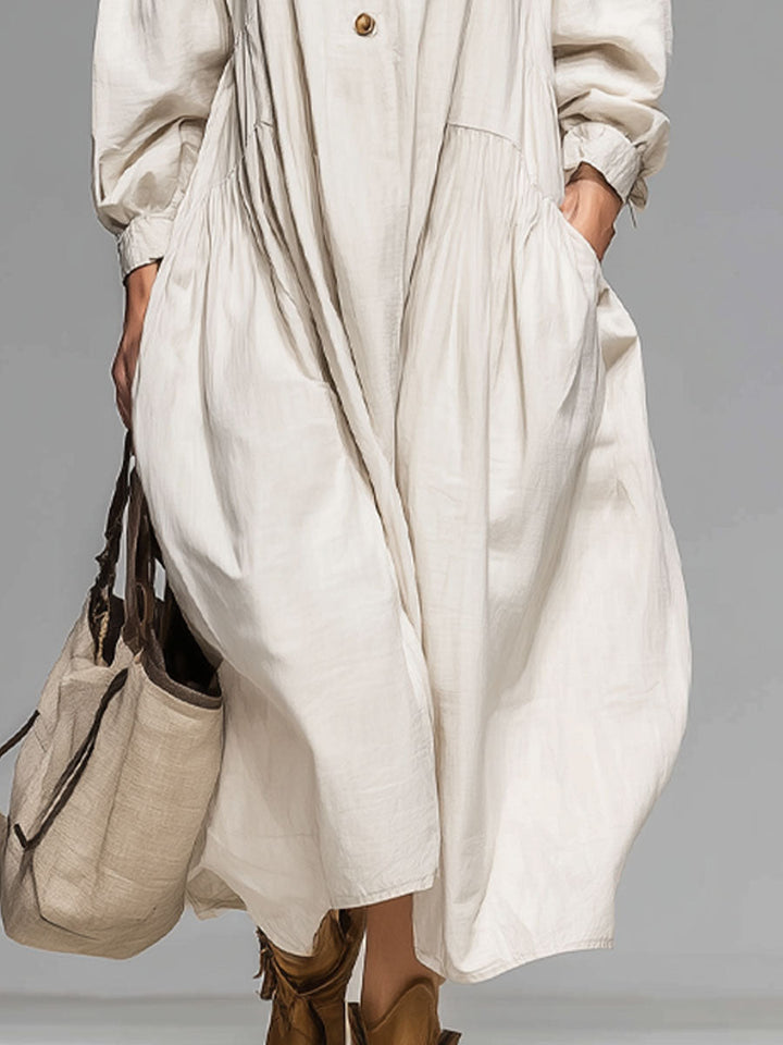 Stylish women's beige midi dress featuring a loose fit, long sleeves, and practical button-front with pockets.