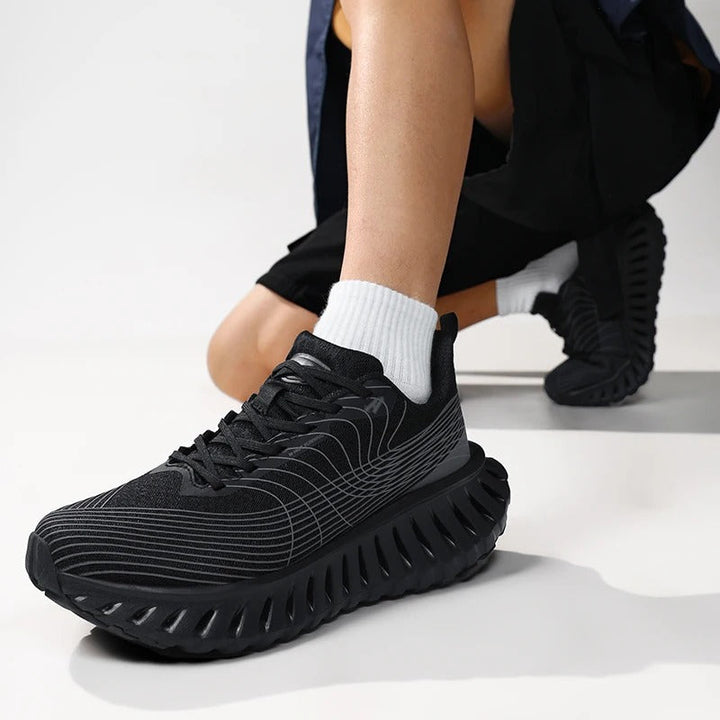 Close-up of black and green running shoe upper, highlighting breathable fabric texture