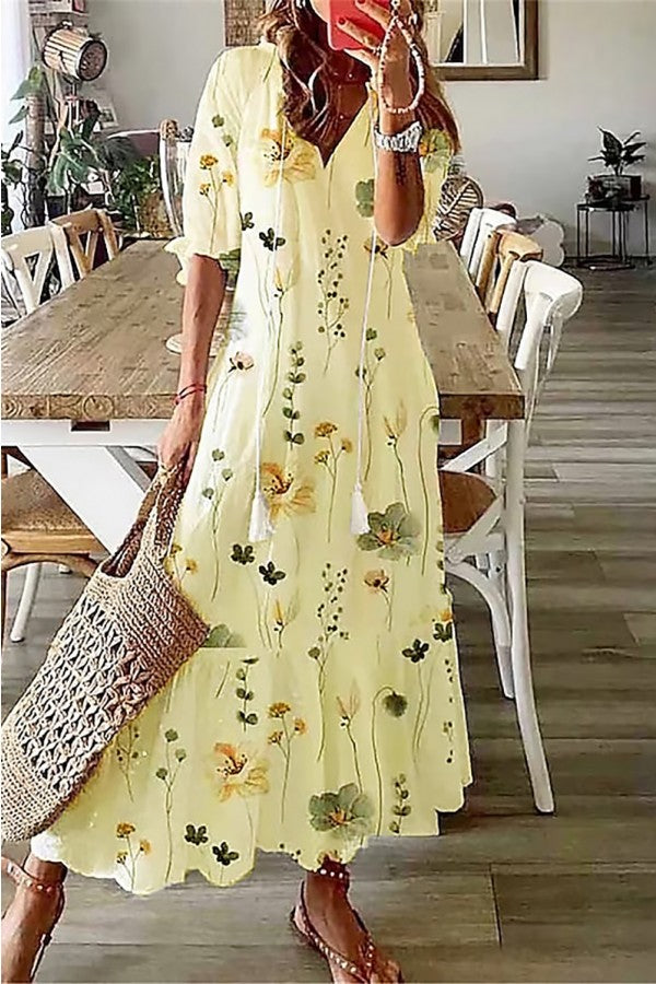 Close-up of a women's V-neck floral maxi dress, showing delicate tassels & a vibrant, casual elegant pattern.