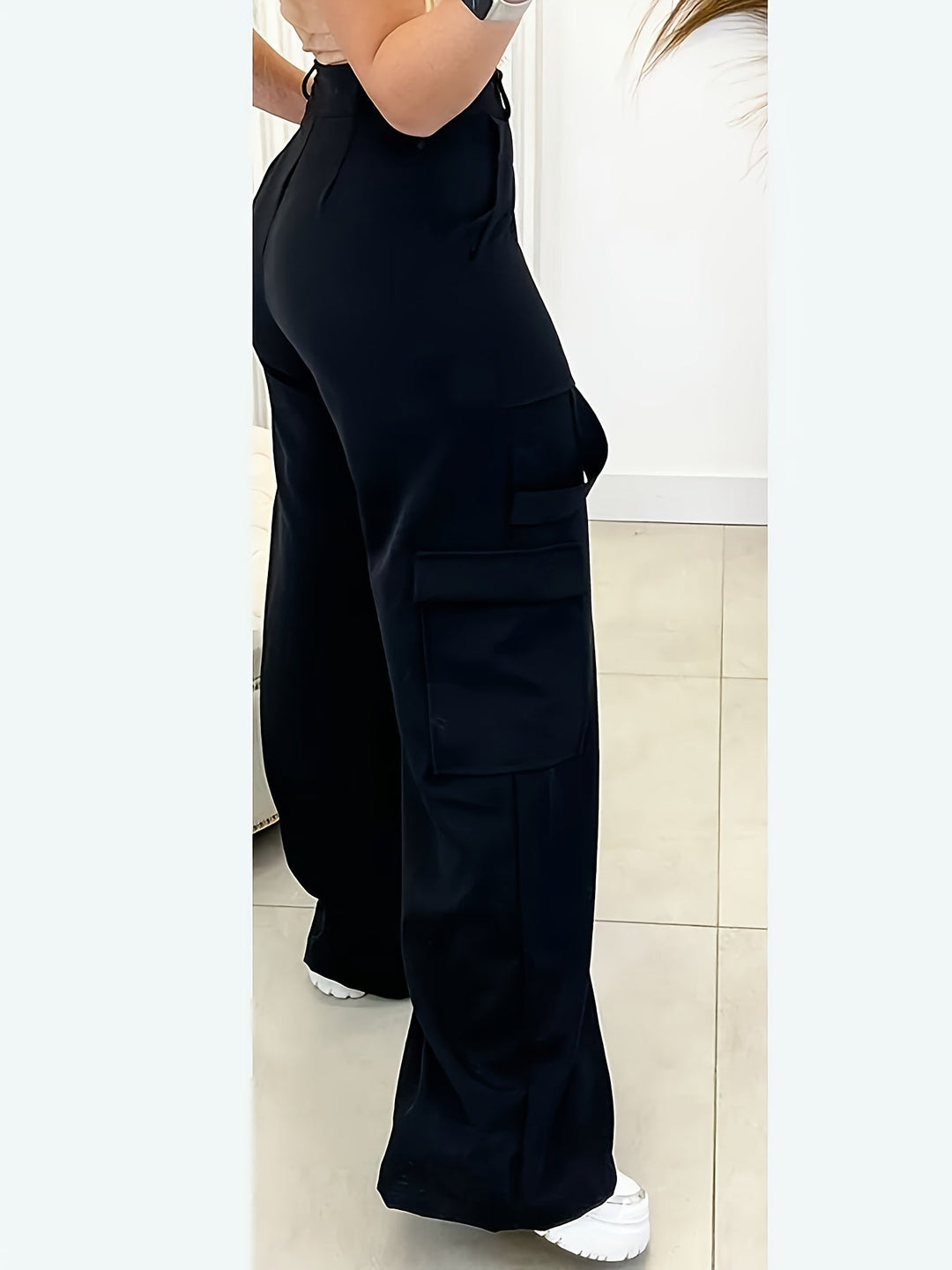 Stylish women's black high-waist wide-leg pants with practical cargo pockets. Modern, chic everyday fashion.