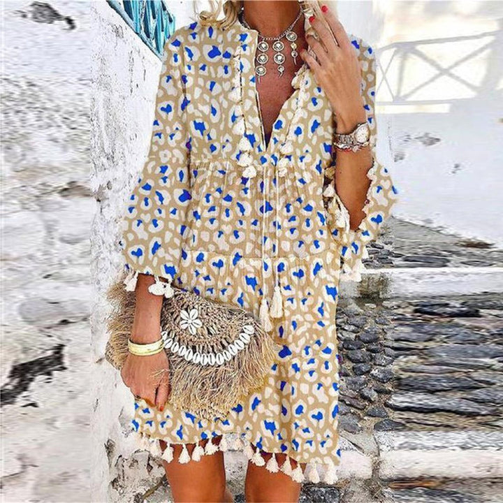 Bohemian V-neck mini dress for women, featuring stylish tassels & bell sleeves. Ideal as a summer casual dress.