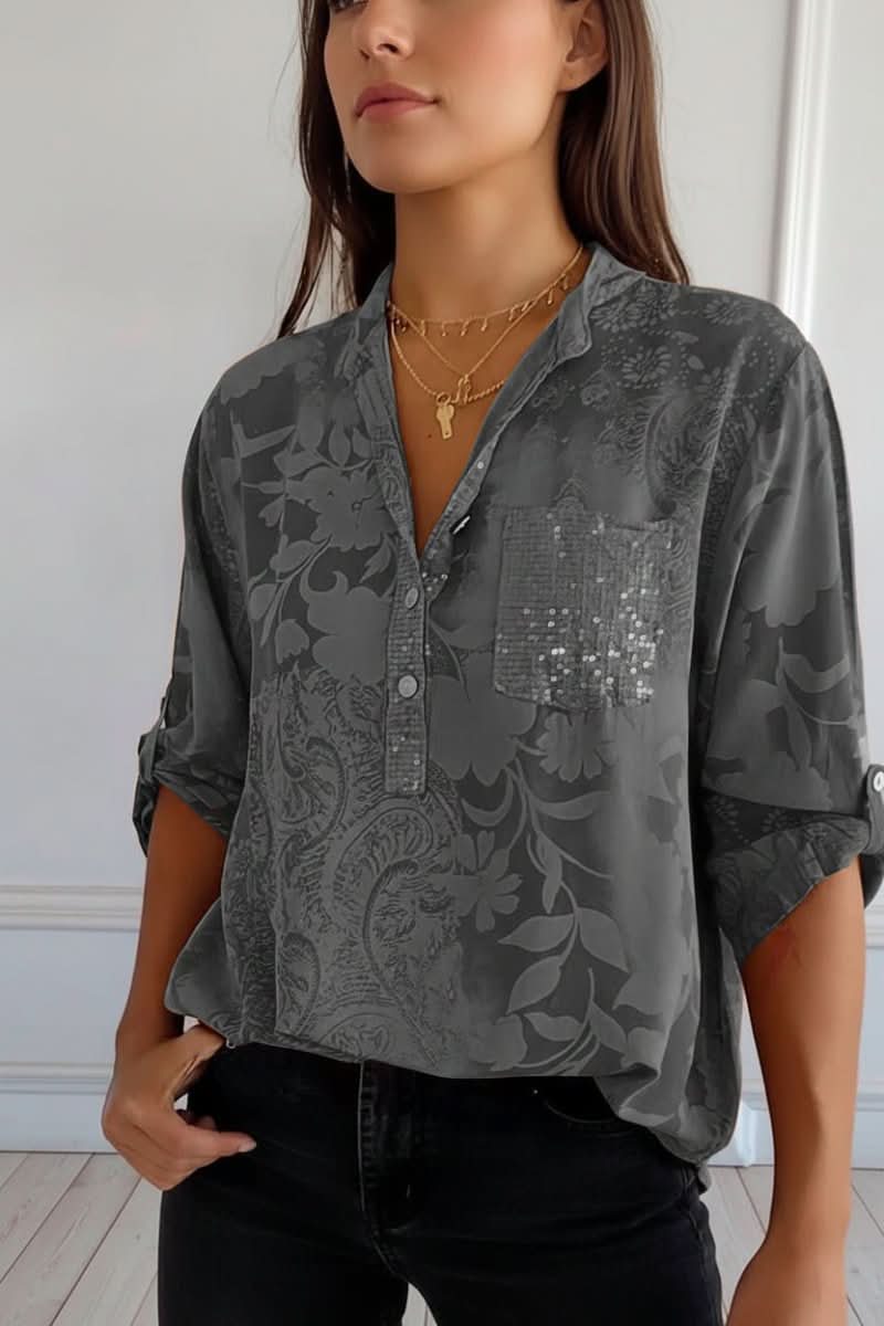 Detailed view of a women's printed blouse, showcasing the unique pattern, long sleeves, and front pocket detail.