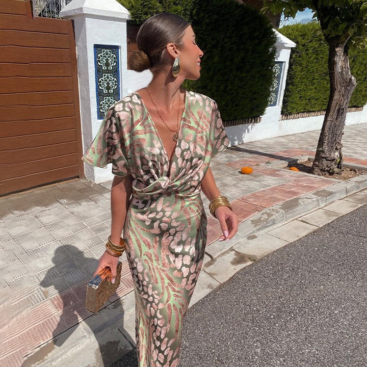 Elegant printed maxi dress for wedding guests, featuring a flattering V-neck, twist front, and draped sleeves.