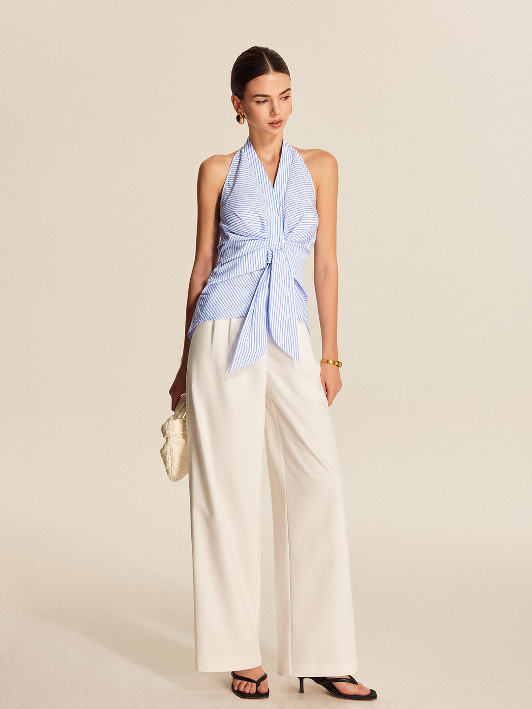 Elegant women's striped halter blouse. Sleeveless tie-front top ideal for workwear or a chic casual look.