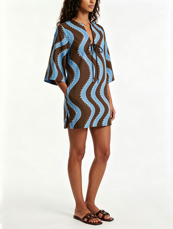 Stylish women's collared mini dress featuring a unique wave print, button front, and comfortable elbow sleeves.