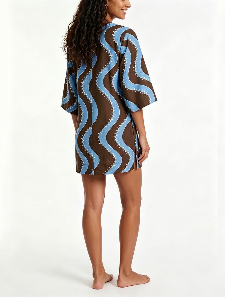 Casual women's shift mini dress with a vibrant wave print, button-down front, and elbow length sleeves.