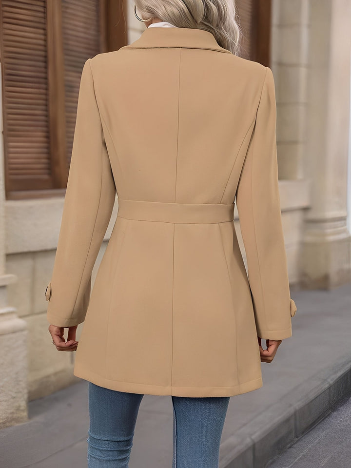 Sophisticated women's long trench coat, double-breasted with adjustable belted waist for fall/spring.