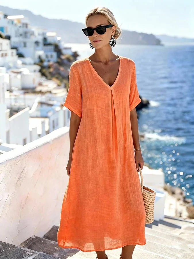 A model gracefully walking in a Women's V-Neck Midi Dress, showcasing its relaxed fit.