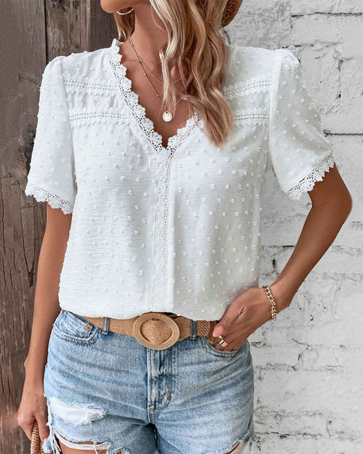 Model wearing a white Women's Swiss Dot V Neck Top with lace, perfect for boho summer fashion & casual elegance.