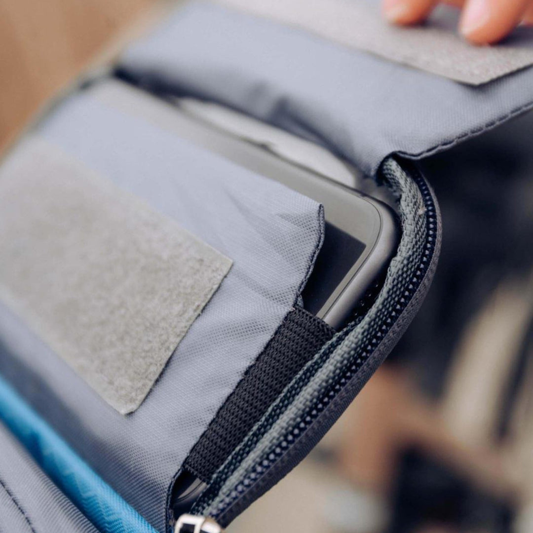 Cyclist using a touchscreen phone through a waterproof handlebar bag on their bike.