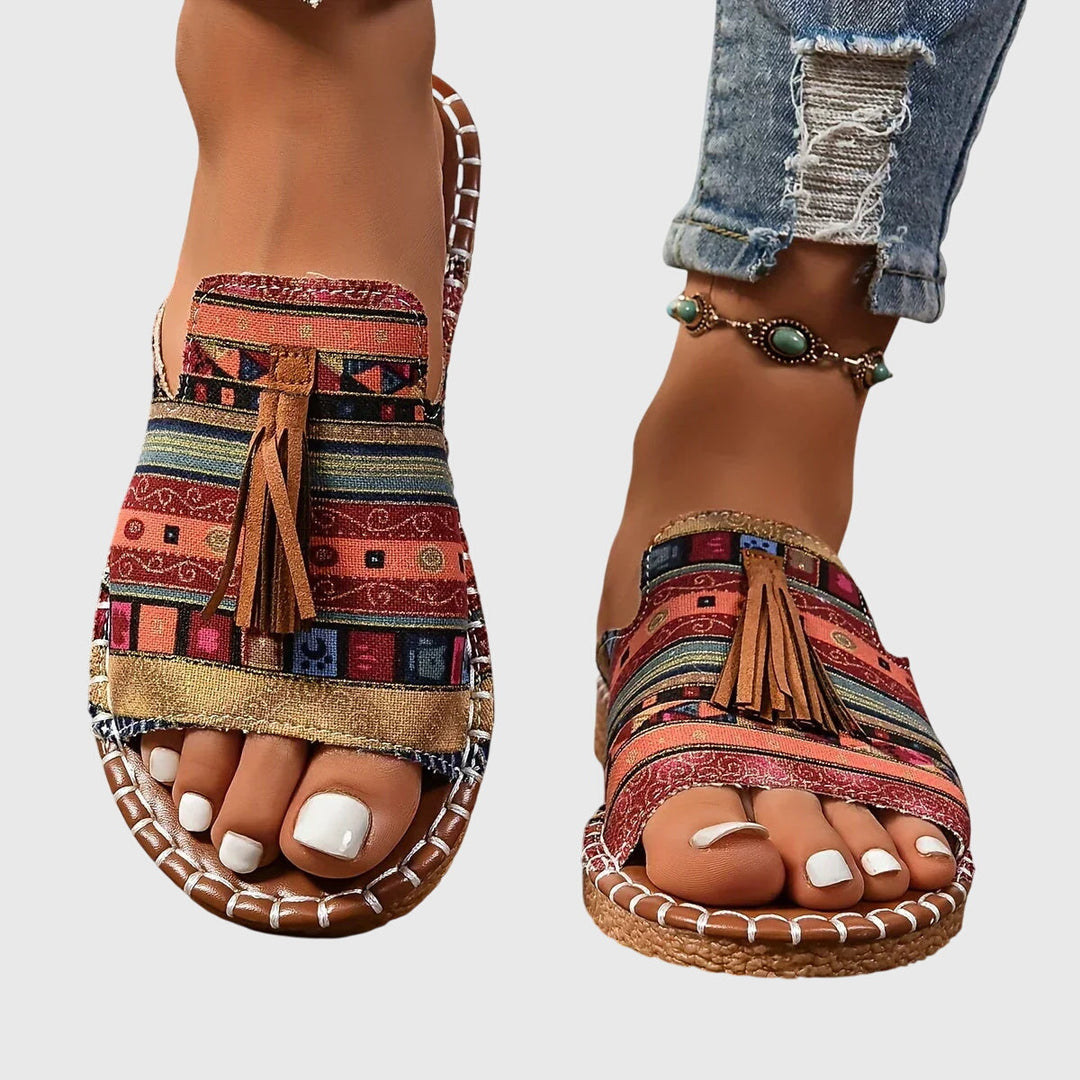 Close-up of women's comfortable slip-on sandals with stylish tassel straps, perfect for summer vacation.