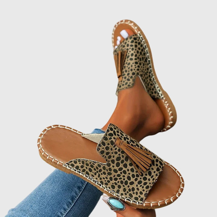 Side view of chic women's open-toe sandals, comfortable and easy slip-on with tassel details.