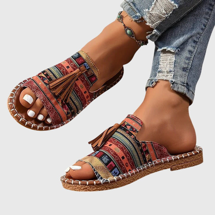 Women's comfortable vacation sandals with easy slip-on design and decorative tassel accents.