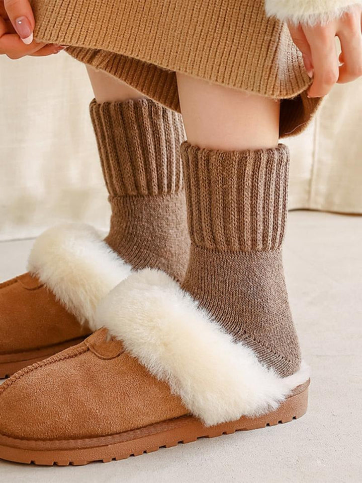 Pair of women's comfortable gray wool blend socks folded neatly, ideal for winter warmth