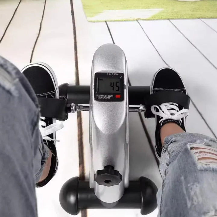 Portable mini exercise bike for legs & arms, perfect for under-desk use. Quiet, adjustable resistance for home fitness.