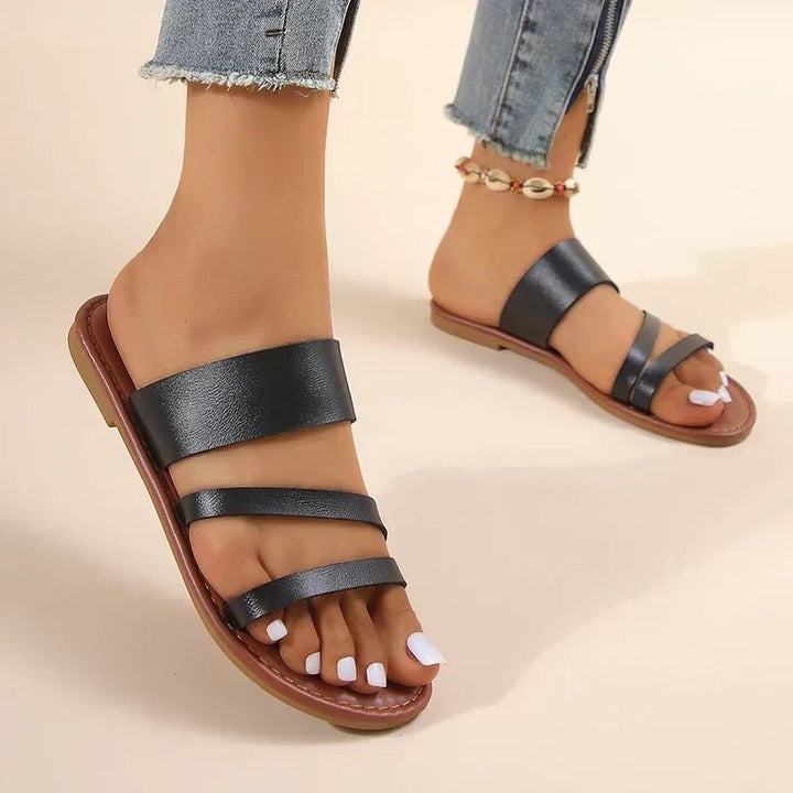 Cushioned women's flat sandals with stylish cross-straps, great for casual summer outings.