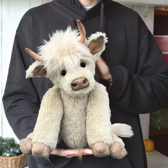 Fluffy Scottish Highland Cow plush toy, handmade from alpaca. Cute, shaggy stuffed animal for home decor.