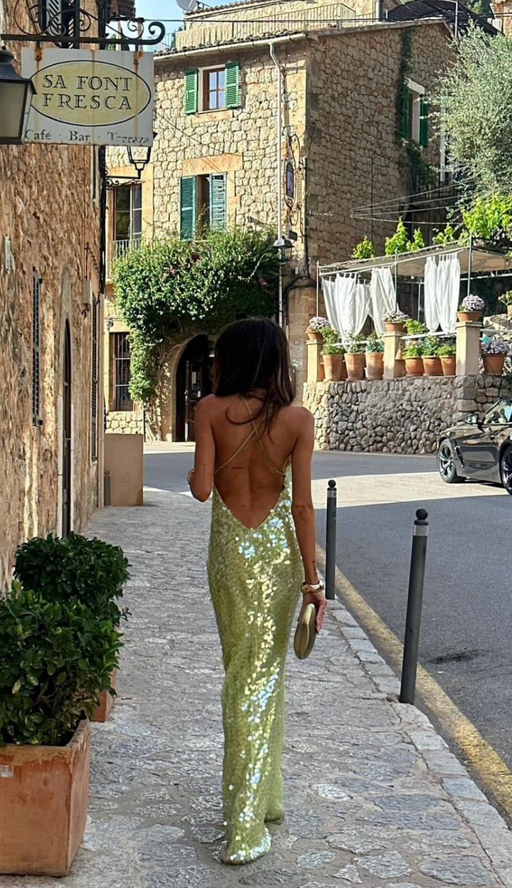 Luxurious green sequin formal gown. This backless homecoming dress offers women a dazzling party look.