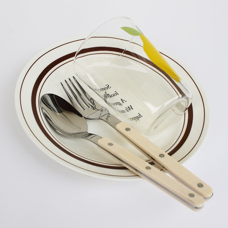 Complete 24-piece engraved stainless steel dining set, including forks, knives, and spoons.