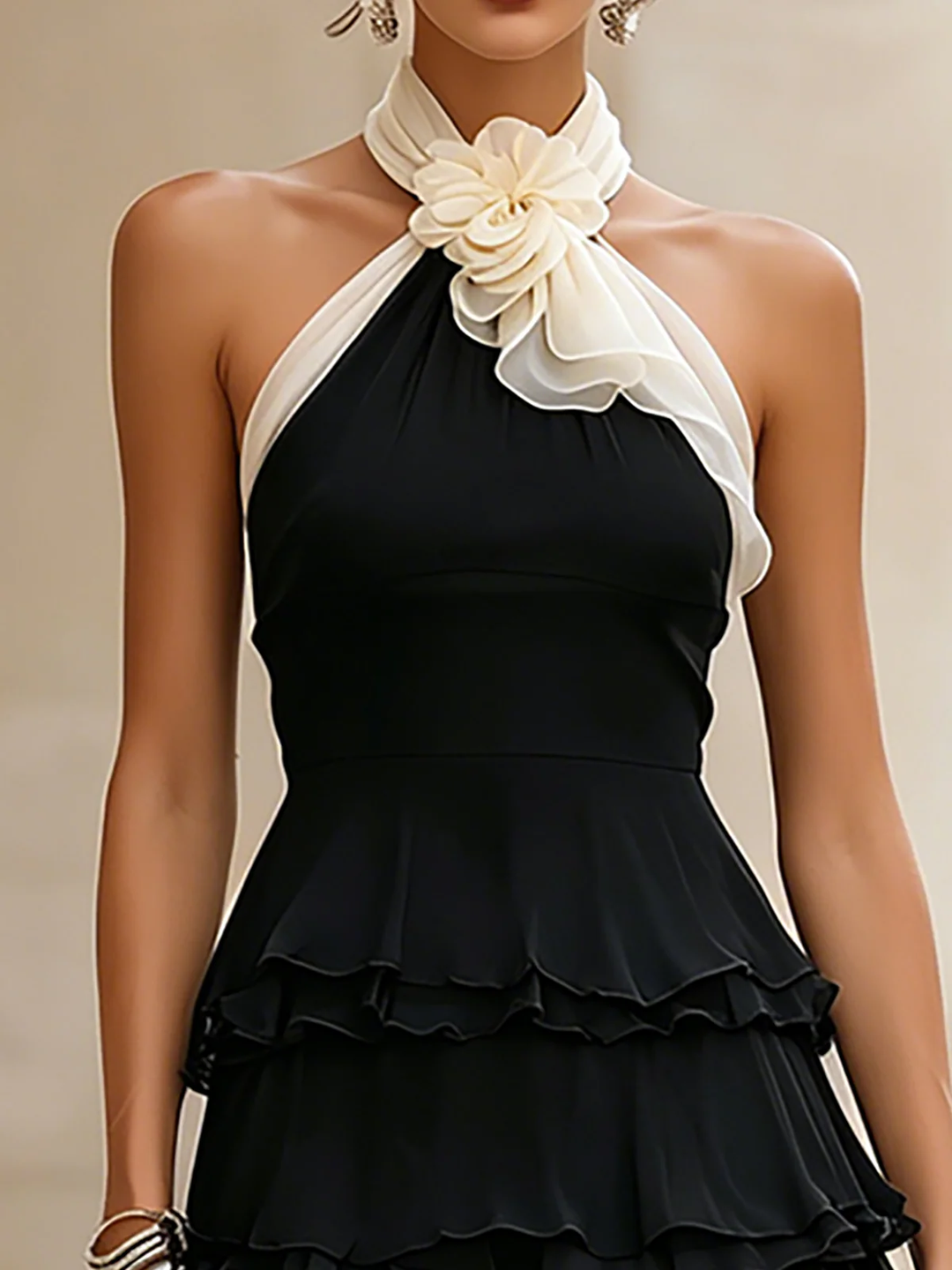 Women's black halter mini dress featuring a rosette & tiered ruffles. Ideal for party wear & special occasions.