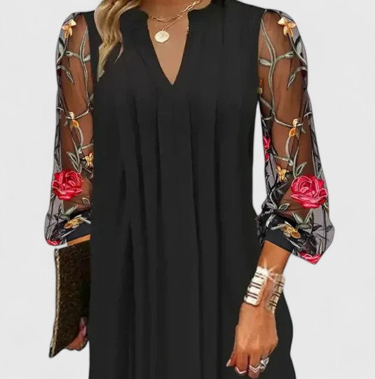 Stylish women's black V-neck mini dress, featuring long sleeves. Elegant & chic for cocktail parties & sophisticated events.