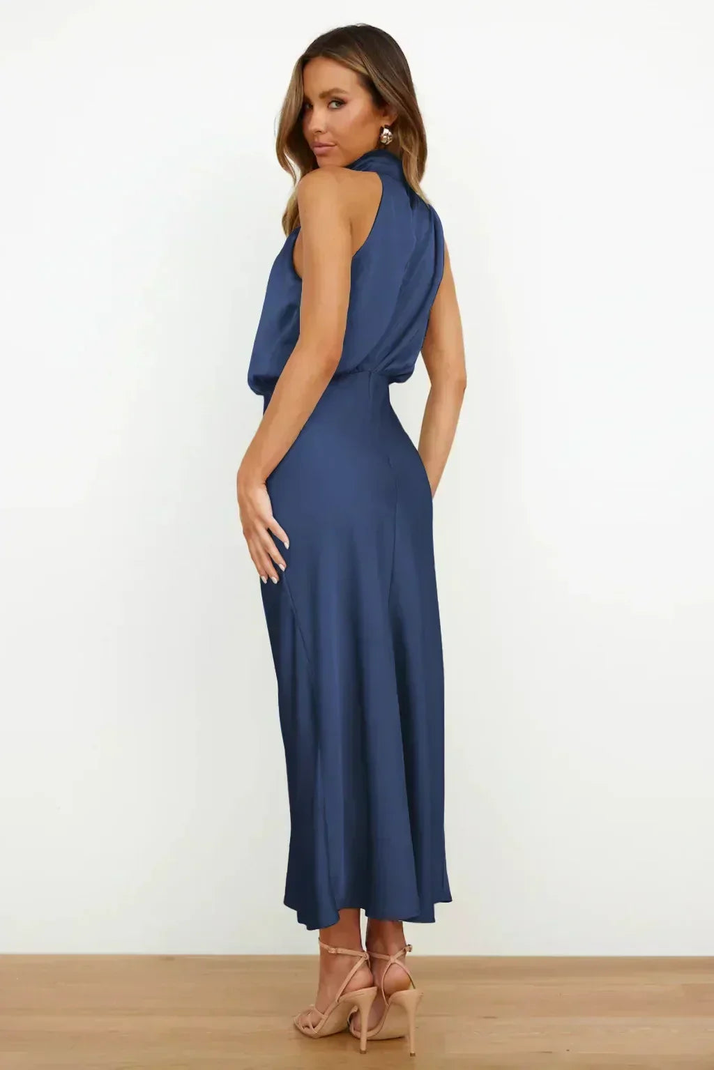 Women's sophisticated halter prom gown in green, with a stunning open back & long flowing skirt.