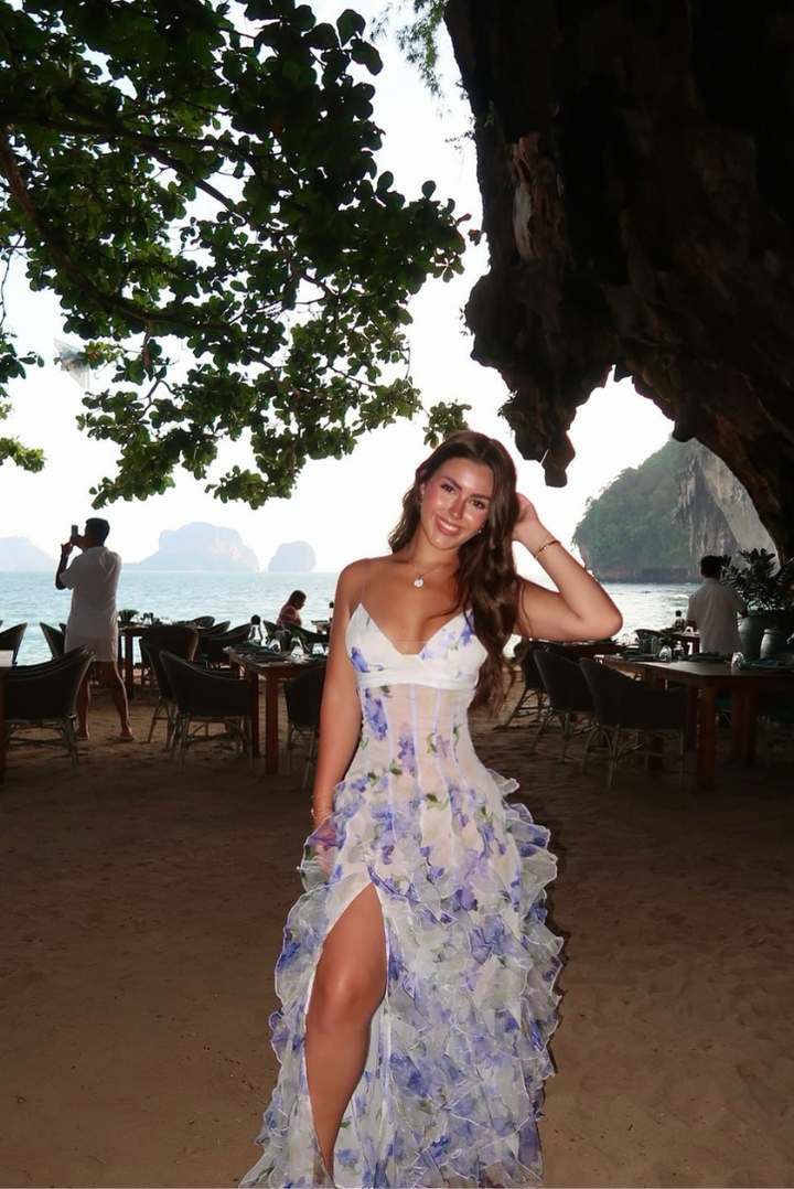 Elegant blue floral V-neck maxi dress with a corset waist and flowing ruffles, ideal for summer parties.