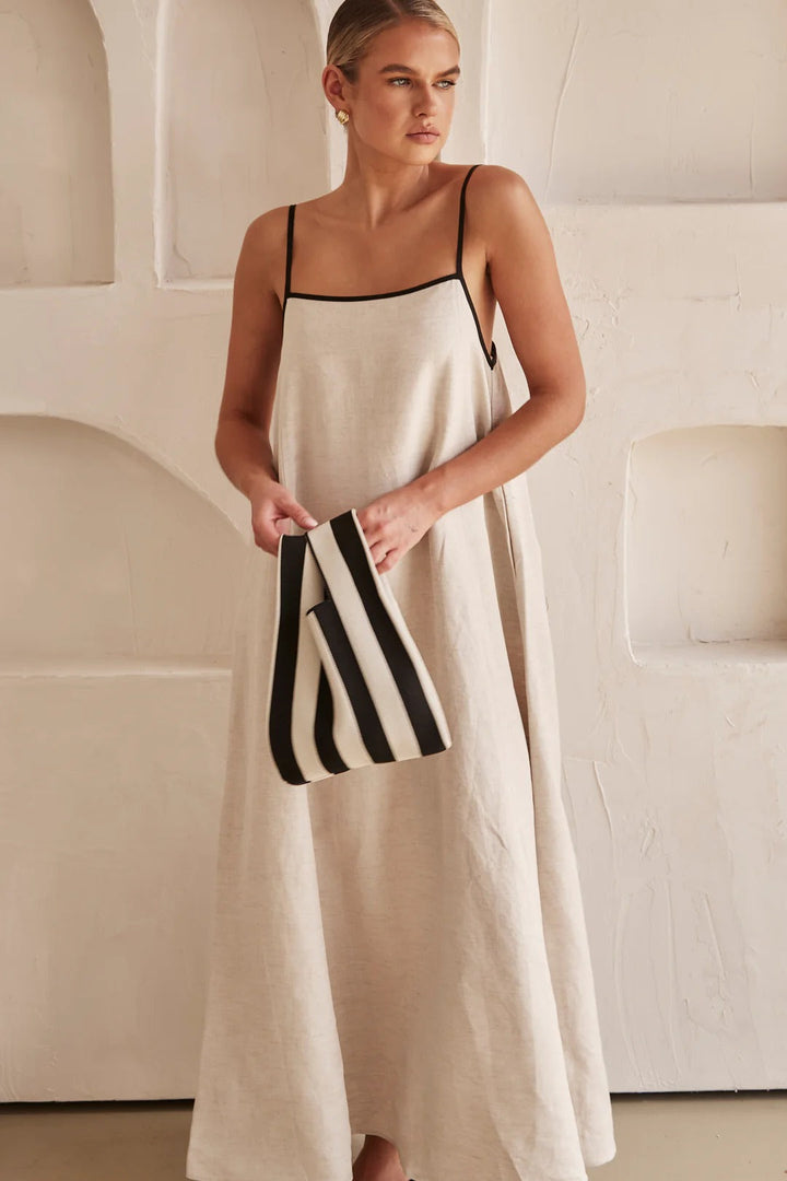 Flowy women's resort wear maxi dress, cream color, with delicate spaghetti straps and contrast trim.