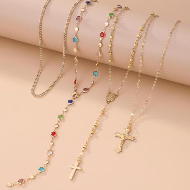 Gold layered necklace set with a petite cross charm, an elegant and versatile women's jewelry piece.