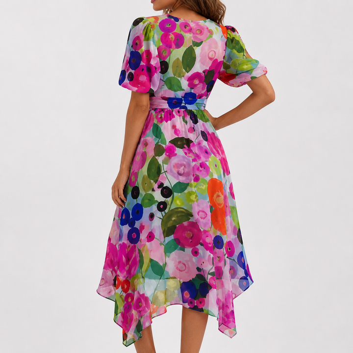 Women's elegant floral midi dress, plunge V-neck, flutter sleeves, high-low hem, styled for a summer event.