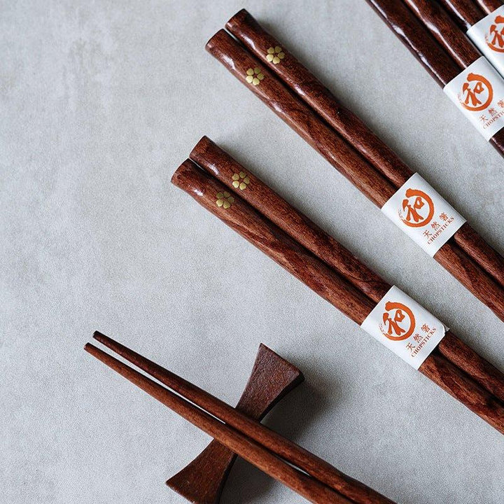Handcrafted wooden chopsticks with intricate golden cherry blossom design. Japanese tableware gift set.