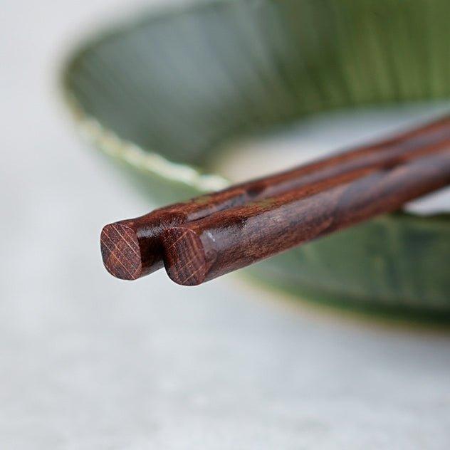 Five pairs of elegant wooden chopsticks, featuring golden cherry blossoms, for authentic Japanese dining.