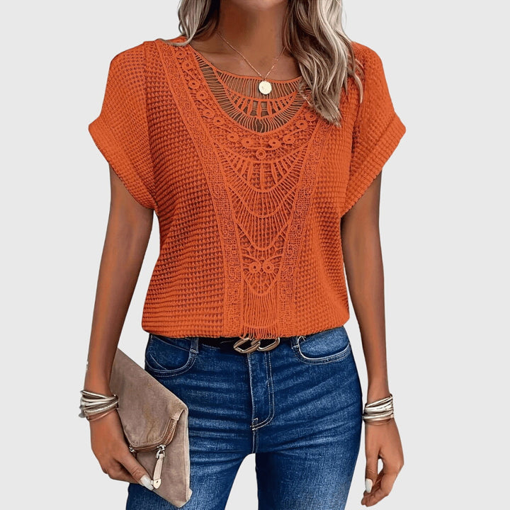 Full view of a woman wearing a flowy, elegant long-sleeve lace blouse in classic Ibiza style.