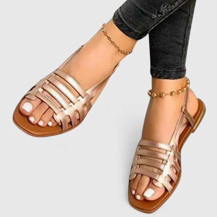 Stylish women's flat sandals with shimmering metallic woven straps and a comfortable open-toe slingback design.