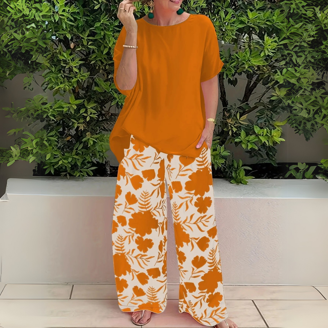 Stylish plus size women's two-piece outfit featuring a vibrant floral print top and relaxed wide-leg pants for fashion & comfort.