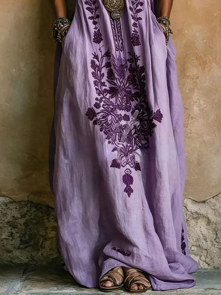 Flowing purple kaftan maxi dress with elegant embroidered print, batwing sleeves & a V-neck, ideal for women.