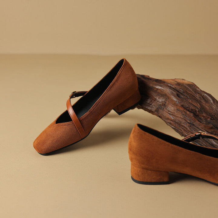 Women's elegant black suede block heel pumps with a sophisticated buckle strap detail.