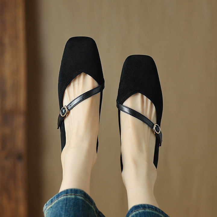 Isolated image of a tan suede block heel pump, showcasing its classic shape and buckle strap.