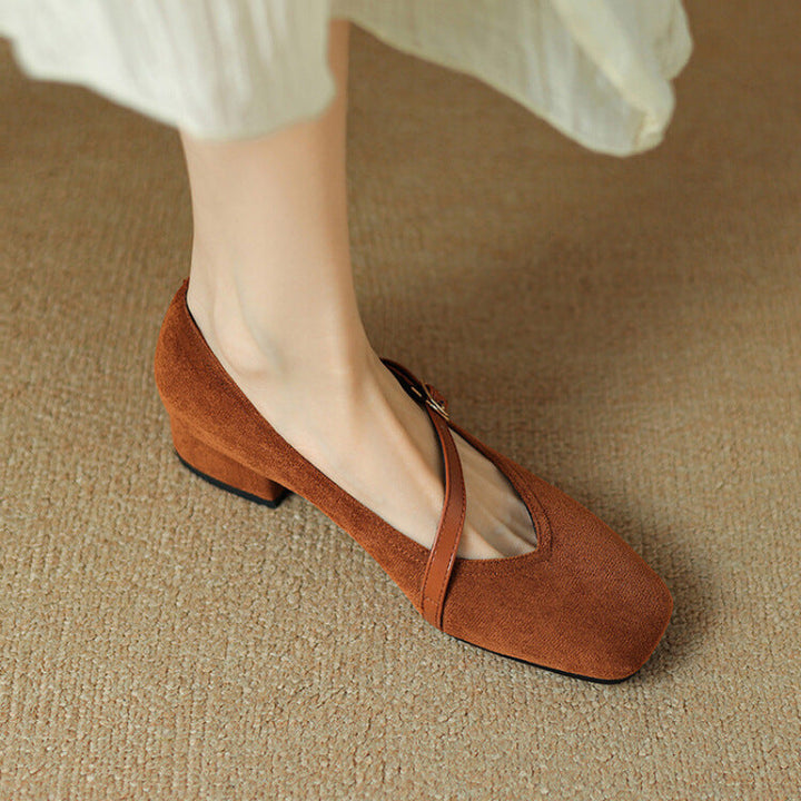 Detail of the comfortable block heel on a women's black suede pump, stable and chic.