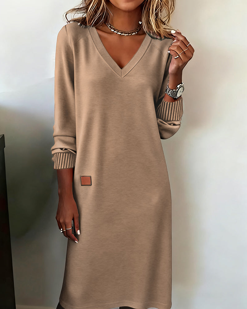 Woman in a sophisticated V-neck long sleeve midi dress, showcasing its elegant office and casual style.