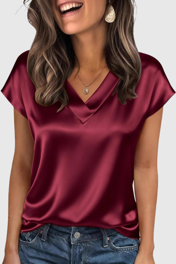 Stylish loose-fit women's summer blouse. Comfortable V-neck top, ideal for a relaxed yet elegant look.