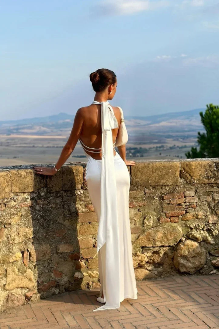 Long sleeveless white maxi dress with backless halter style, great for vacation or elegant events.