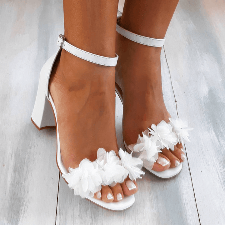 Elegant white women's block heel sandals with secure ankle strap, perfect for dressy occasions or versatile fashion.