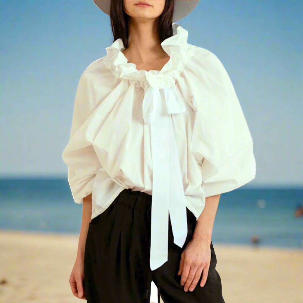 Modern women's white blouse with classic elegant puffed lantern sleeves and a fashionable ruffled bow tie.