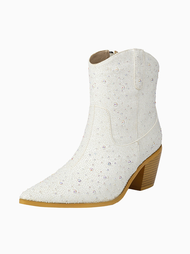 Close-up of white cowgirl boots featuring intricate pearl & rhinestone embellishments, a glamorous choice for brides.
