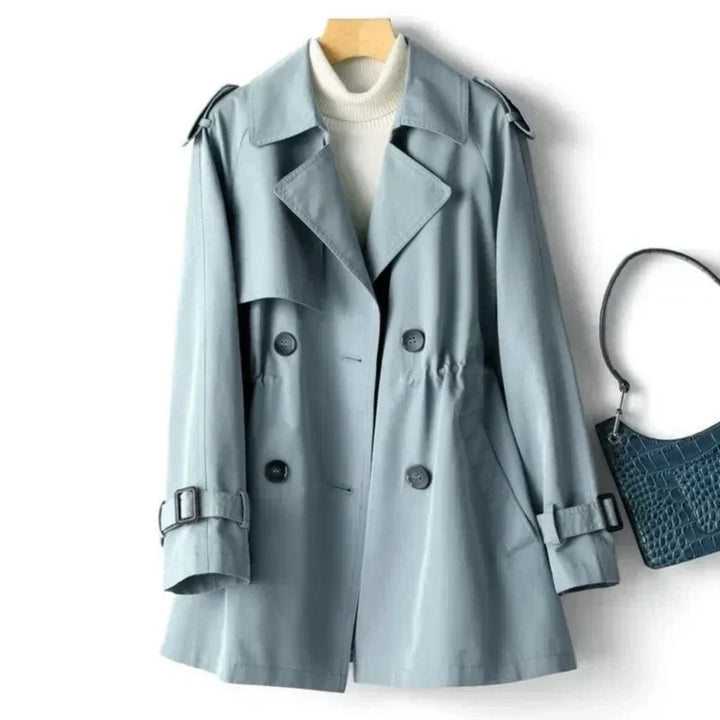 Formal women's double-breasted trench coat with elegant belt detail, a classic choice for office and fall outerwear.