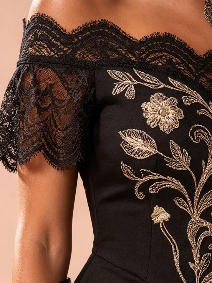 Women's black evening gown with intricate gold floral pattern, off-shoulder style & dramatic high-low asymmetrical hem.