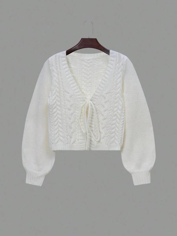Stylish women's outerwear: a cozy, elegant cable knit tie-front cardigan in a warm color.